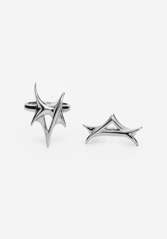 Close up two silver rings with a spike design against a white studio backdrop