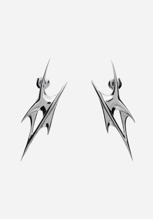 A pair of silver-toned geometric drop earrings with a sharp, angular spike design, shown against a plain light gray background.