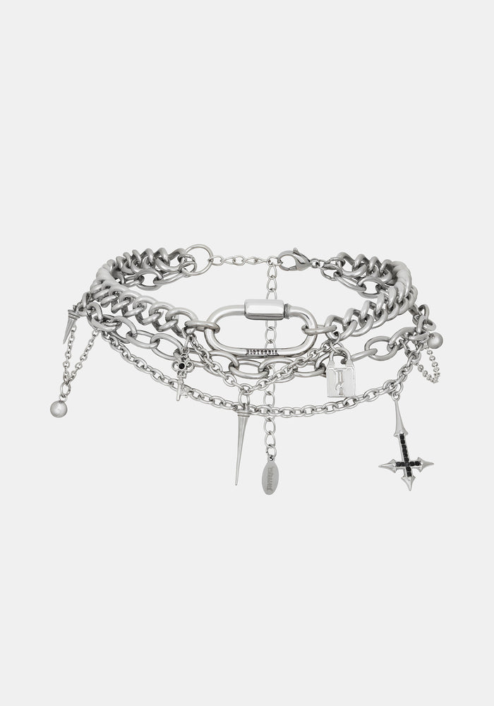 A layered silver-tone chain choker bracelet featuring chunky and delicate chains, a central ring, and dangling charms including a cross, key, and beads, shown against a light gray background.