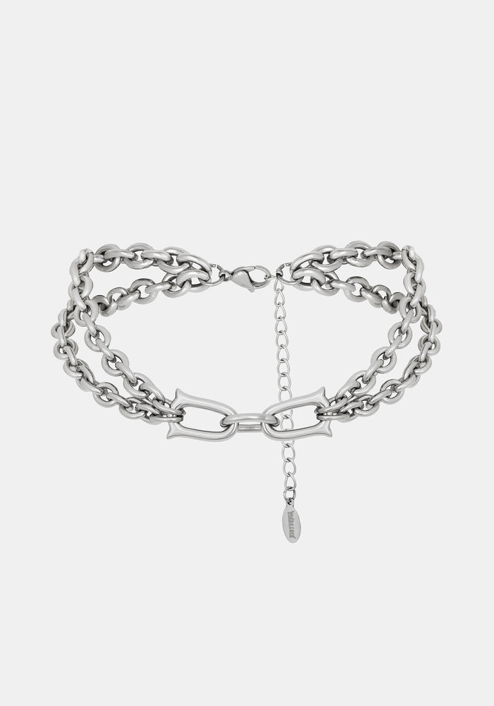 A close-up of a chunky silver double chain choker necklace with extender clasp