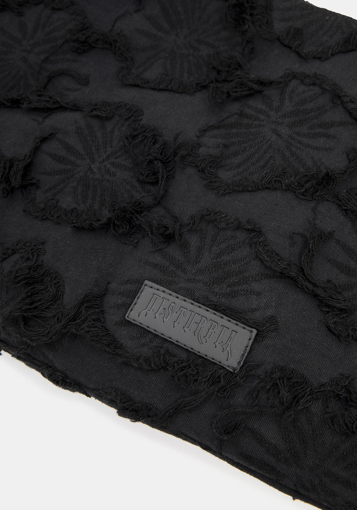 Close up of brand logo on a black textured shoulder bag